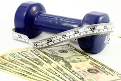 several bills of american dollars in front of a blue dumbbell wrapped with a measuring tape