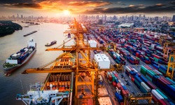 Logistics and transportation of Container Cargo ship and Cargo plane with working crane bridge in shipyard at sunrise, logistic import export and transport industry background