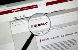 MONTREAL, CANADA - SEPTEMBER, 25 : Equifax Canada home page with information about cybersecurity incident under magnifying glass . Equifax Inc. is a consumer credit reporting agency. Selective focus.