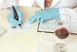 A crime scene forensic scientist obtains fingerprints from a glass using latent powder and tape and then writes down details. Details are fictitious.