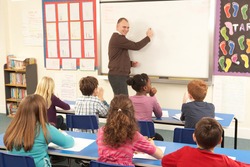 Schoolchildren Studying In Classroom With Teacher