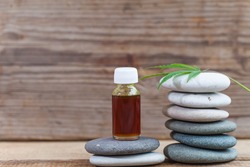 Green leaves of medicinal cannabis with extract oil on a wooden table pebble pyramid