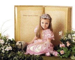 A beautiful little princes posed before a "Once upon a time" book and surrounded by flowers,foliage and a bunny.