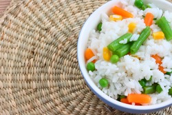 Close up view of cooked rice in bowl - with mixed of colorful vegetable on natural background