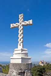 Beautiful Christian cross carved in stone with interlaced effect located at the highest point of the Sintra hills overlooking the palace of Pena (Cruz Alta)
