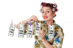 Young housewife is hanging hundred dollar bills on clothesline on a white background. Money concept.
