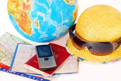 concept of traveling all over the world with mobile phone,passport,money,map and globe isolated on white