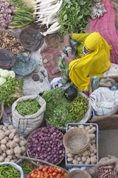 PUSHKAR, INDIA - NOVEMBER 8: Unknown Indian women sells fruit and veg on November 8, 2008 at a street market during the annual Camel Fair in Pushkar, Rajasthan, India