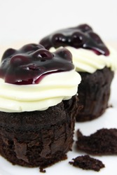 cake chocolate with cream cheese and fresh blueberries on white plate closeup
