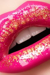 Glamour fashion bright pink lips gloss make-up with gold glitter. Macro of woman's face part. Sexy glossy lip makeup, luxury lady