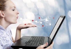 Concept - young cute woman love laptop computer or internet boyfriend. She sending Air kiss to dating site. Blogger