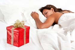 Asleep woman has a surprise present waiting for her in bed