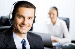 Portrait of happy smiling customer support phone operator in headset at office