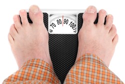 Overweight man standing on a retro style weighing machine isolated on a white background.