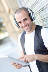 Young man using electronic tablet in the street