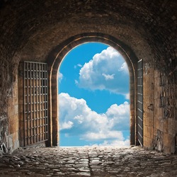 Heaven's gate. Dark tunnel corridor with arch opening to a beautiful cloudy sky. Light at the end of the tunnel.