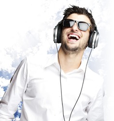 portrait of a handsome young man listening to music against a cloudy sky background
