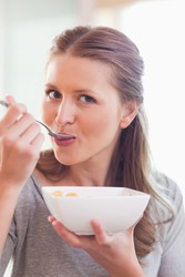 Close up of young female having cereals for breakfast