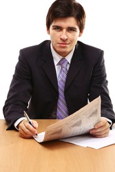 Close-up portrait of a businessman reading newspaper isolated on white background