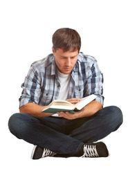Young student reading a book sitting on the floor - isolated on white background