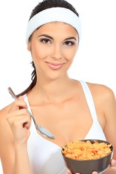 Portrait of a beautiful young woman eating cereal. Isolated over white background.