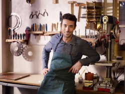 Portrait of adult italian man at work as craftsman in shop with tools in background