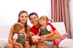 Family portrait where father putting coin to piggy bank