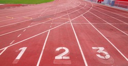 Lanes of a red race track with numbers and red seats in the stadium