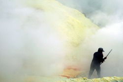 KAWAH IJEN,INDONESIA-SEPT 19:Unidentified miner harvests raw sulphur from the crater of Kawah Ijen volcano in hazardous working environment with minimal protection on Sept 19,2010 in Kawah Ijen.