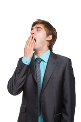 Handsome young business man yawning, businessman cover mouth by hand with eyes closed, wear elegant suit and tie isolated over white background