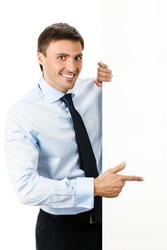 Happy smiling young business man showing blank signboard, isolated over white background