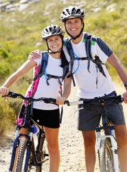 Happy carefree mountain bike couple cycling outdoors and leading a healthy lifestyle.
