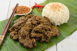 Beef Rendang & Sticky Rice - Malaysian / Indonesian spicy dry beef stew with coconut and sticky rice served on a banana leaf.