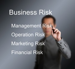 business man writing four type of business risk ( management - operation - marketing - financial ) on whiteboard