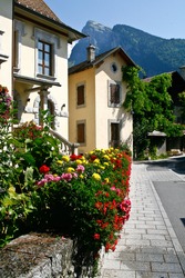 street scene of a french town in the le grand massif, samoens in summer with flowers and mountains in the background