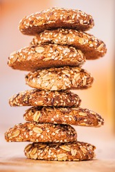 delicious oatmeal cookies with splash of sunflower seeds, sesame seeds on wooden table laid out in row