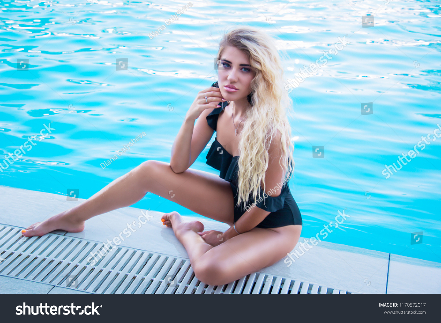 Блондинка позирует у бассейна фото