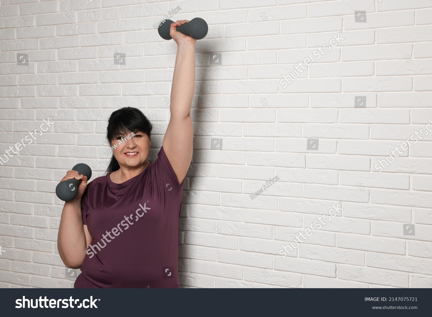 Happy Overweight Mature Woman Doing Exercise Stock Photo