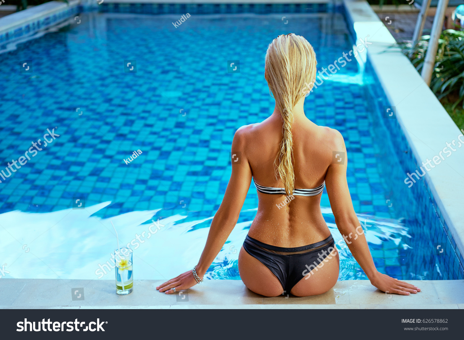 Девушка ласкает норку возле бассейна