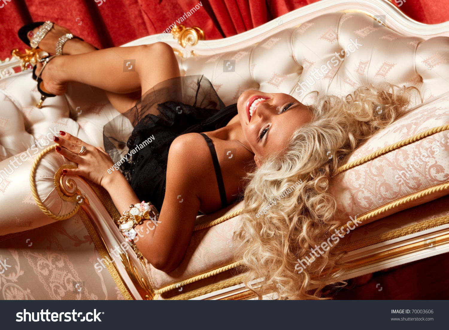 Сексуальная блондинка в роскошных позах на диване