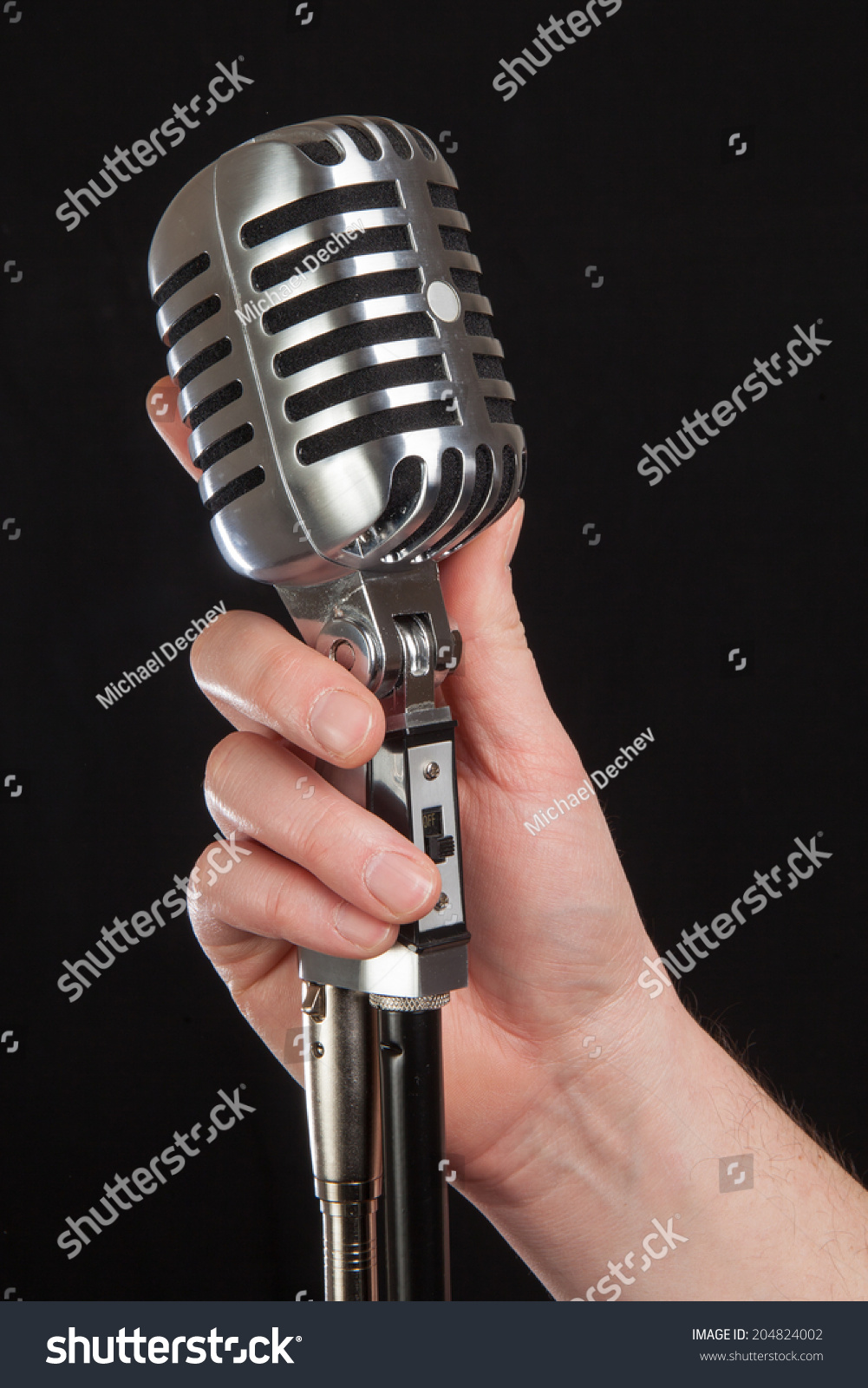 Hand Holding Retro Microphone Over Black Stock Photo