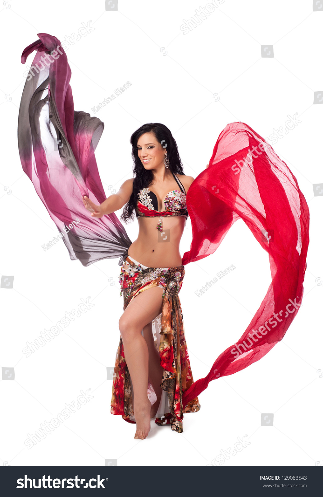A Beautiful Bellydancer In A Multicolor Costume Smiles As She Dances With Two Colorful Flowing