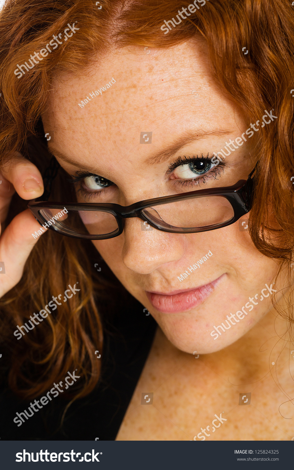 A Beautiful Woman Peering Over Her Glasses In A Seductive Manner Stock