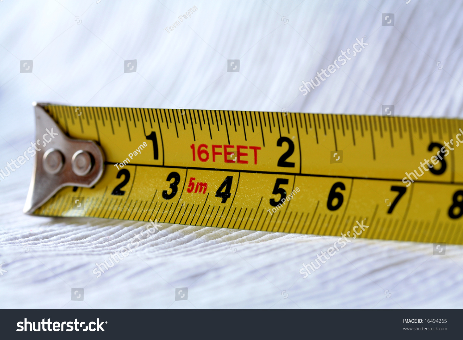 a-16-feet-yellow-tape-measure-with-inches-and-centimetres-stock-photo