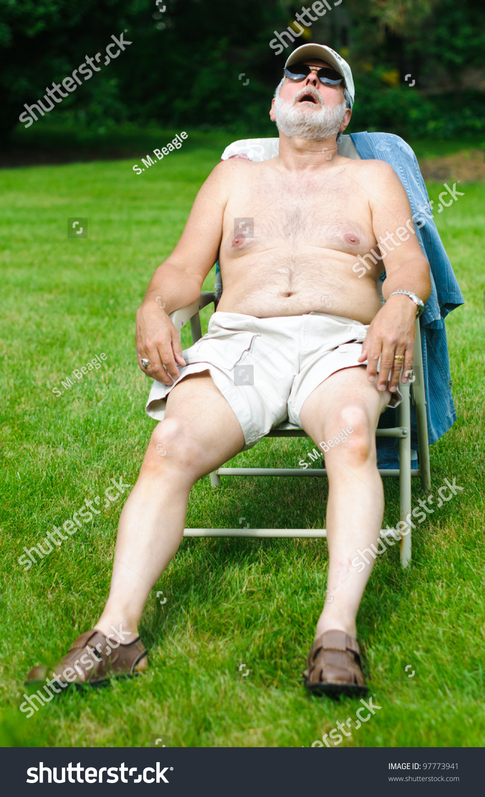 A Funny Picture Of An Older Shirtless Man Sleeping In A Folding Chair