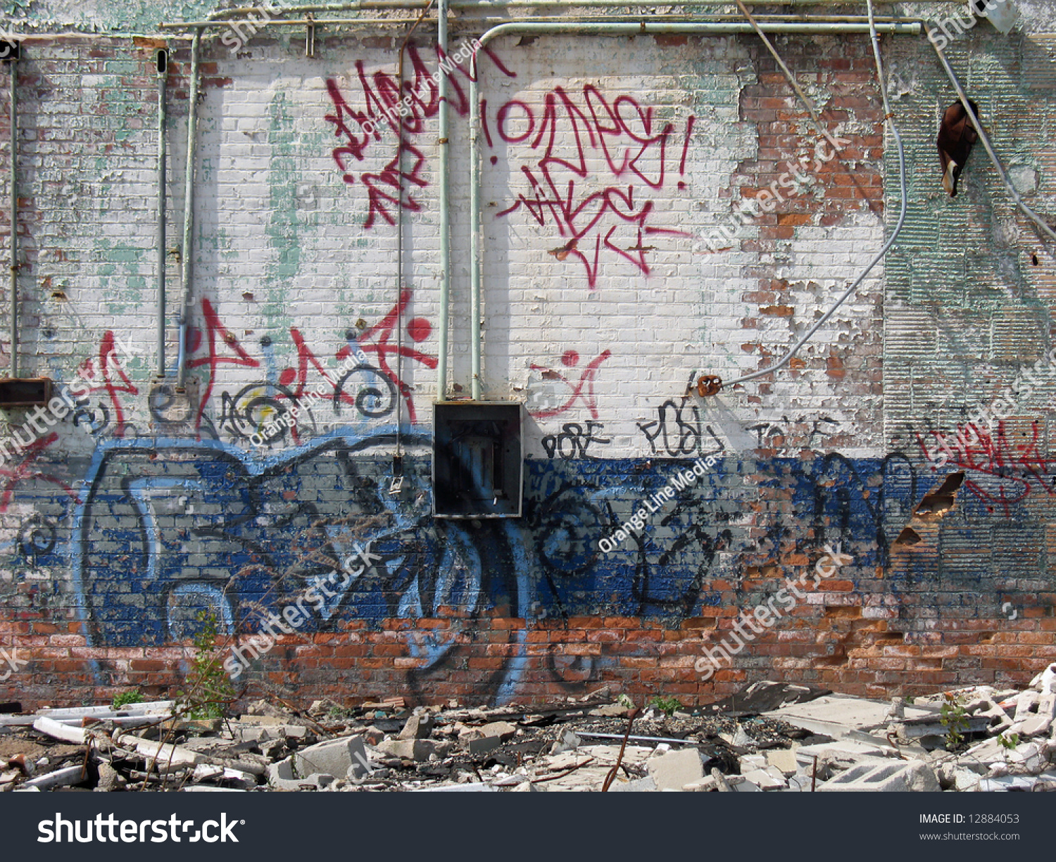 A Graffiti Covered Wall Of An Abandoned Brick Building, Which Is 