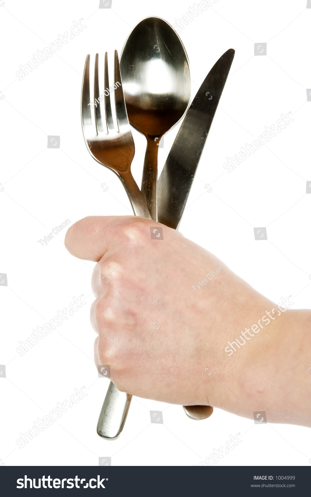 A Knife, Fork And Spoon Being Held By A Womans Hand. Isolated On White