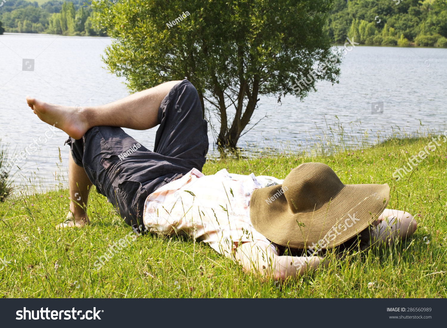 a-man-taking-a-nap-after-meal-with-a-straw-hat-on-face-stock-photo