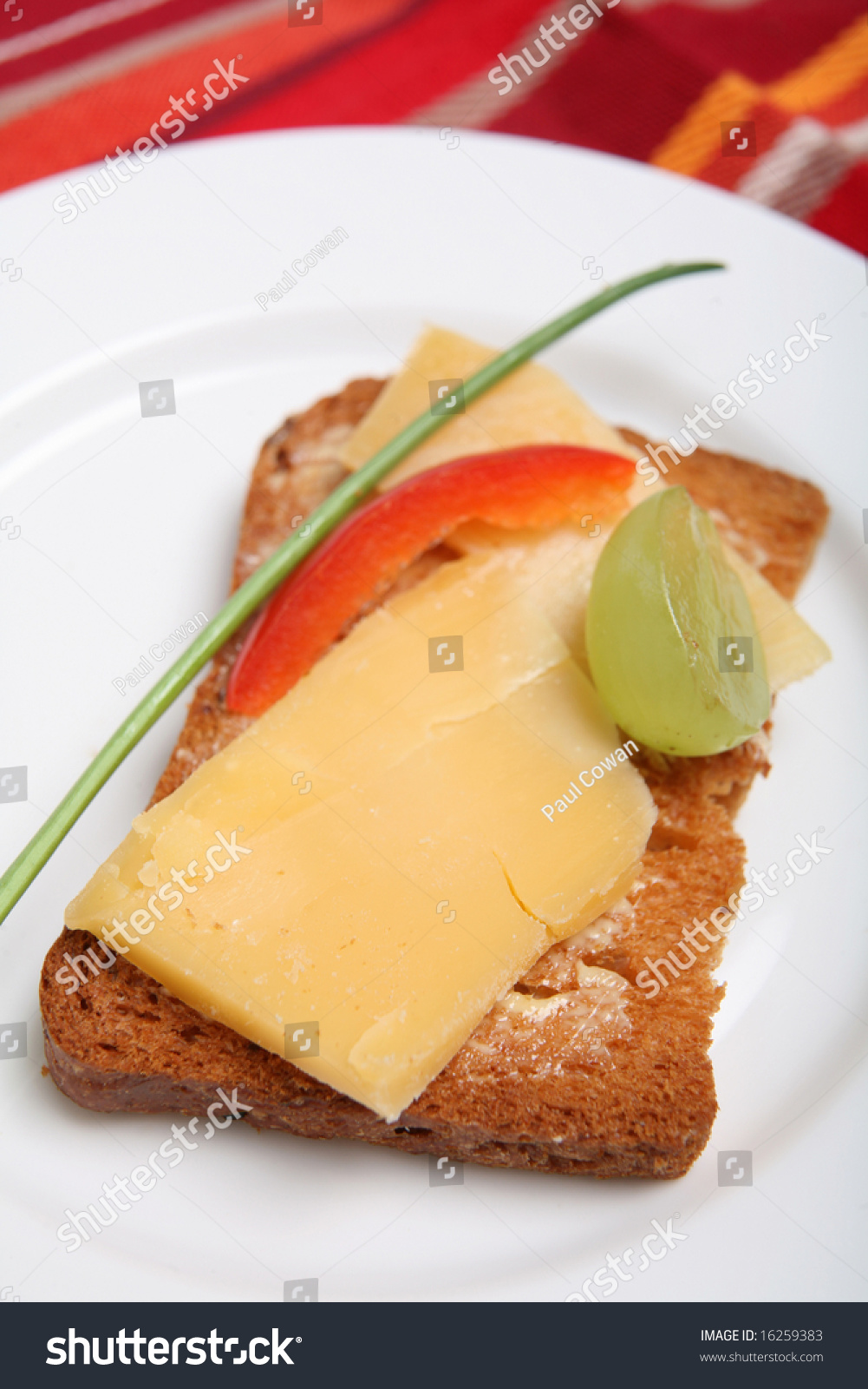 A Rusk Or "Melba Toast" Canape With Dutch Cheese, Half A Grape, A
