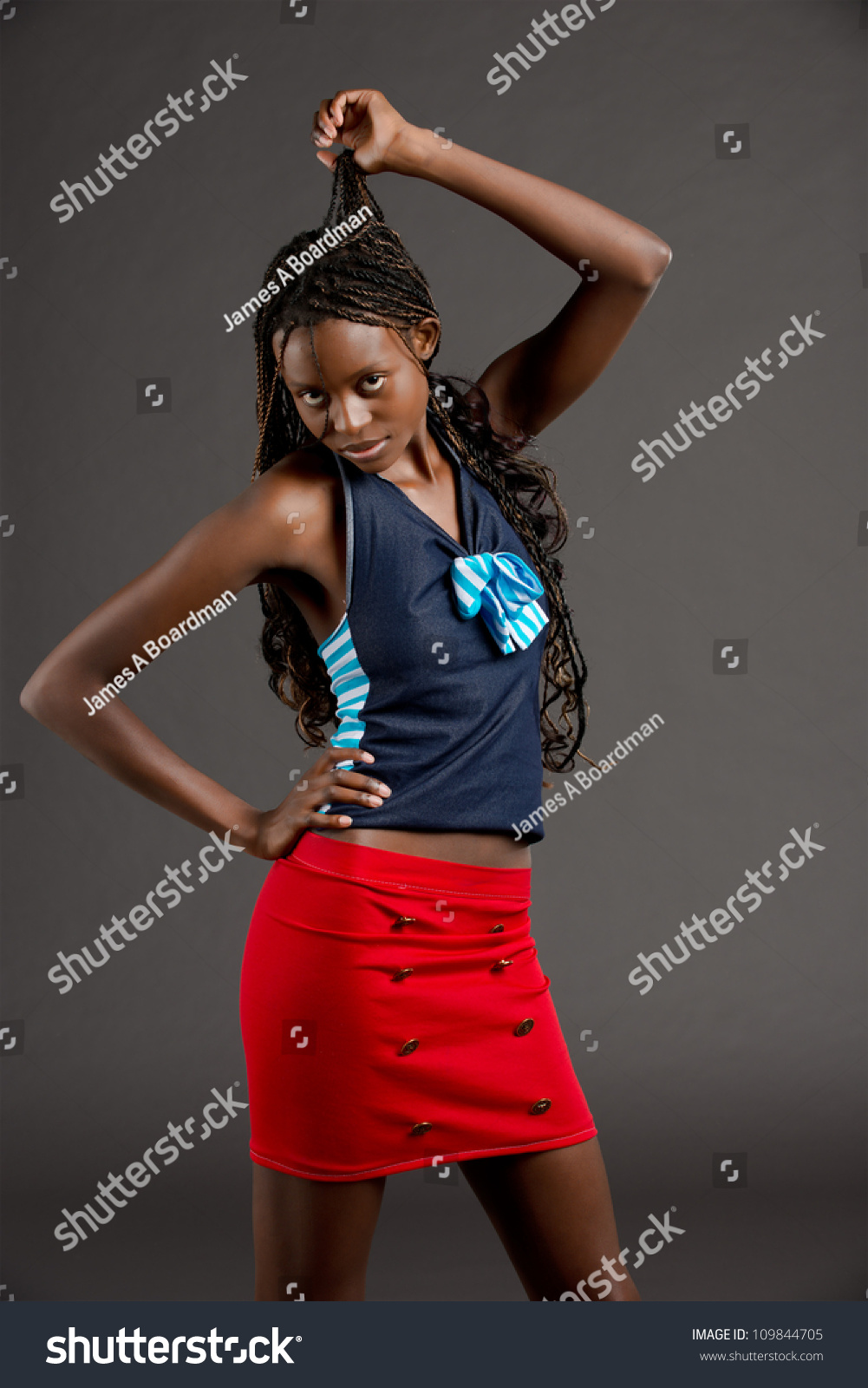 A Tall Beautiful African American Woman In A Bright Red Skirt Stands